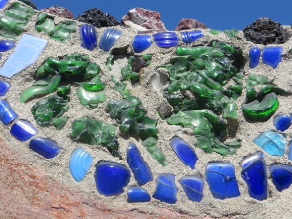 He built and oven in which he cooked bread and melted glass.  The green glass iimbedded in this panel are melted 7-Up bottles.  The blue are from Milk of Magnesia bottles. 